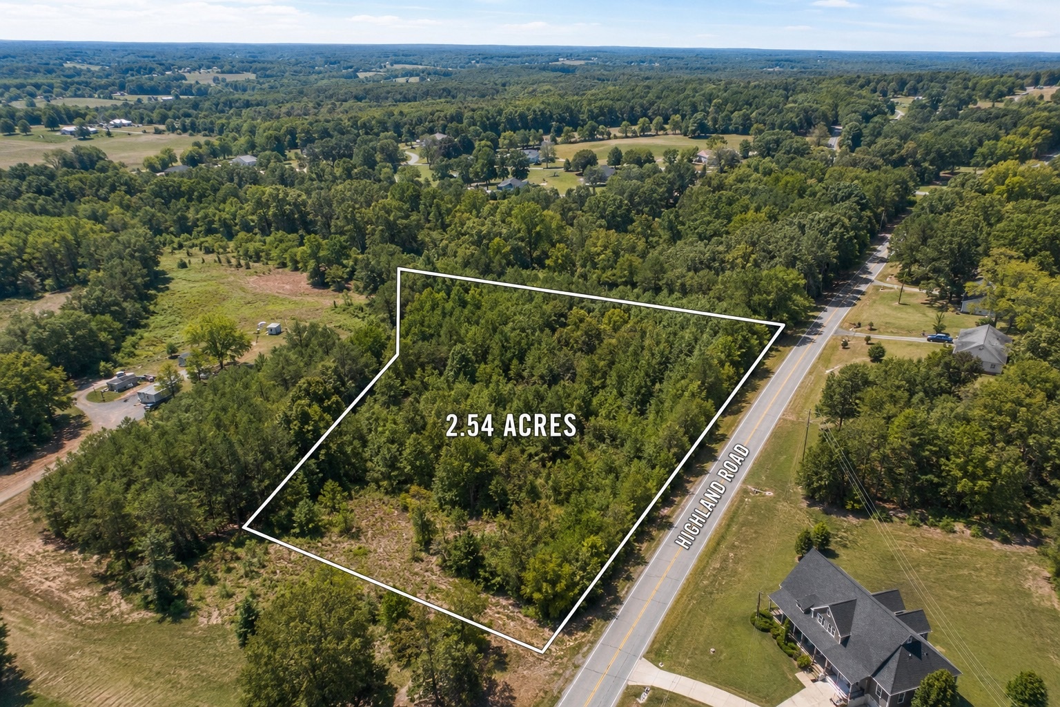 Aerial drone image with property boundary outlining for vacant land